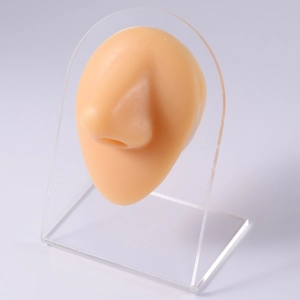 Silicone nose piercing model in natural skin tone with clear acrylic display stand