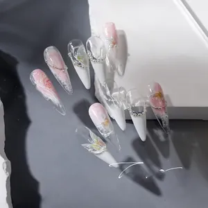 Detailed view of stiletto press-on nails with butterfly patterns and pearl accents