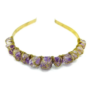 Detail of amethyst raw crystal quartz crown with gold wire wrapping on a metal headband