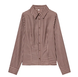 Detail of classic plaid shirt fabric showing fine brown and beige check pattern texture