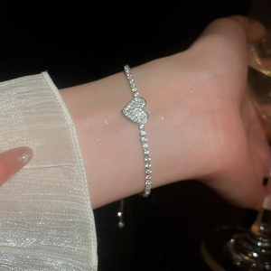 Close-up of sparkling zircon heart tennis bracelet with adjustable pull clasp on wrist