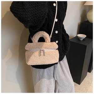 Detail van beige teddy schoudertas met dubbele rits en zachte pluche lamswol textuur