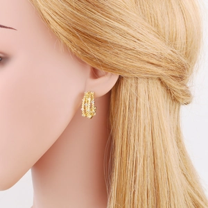 Detail of gold-plated triple-layer twisted hoop earrings with sparkling zircon accents