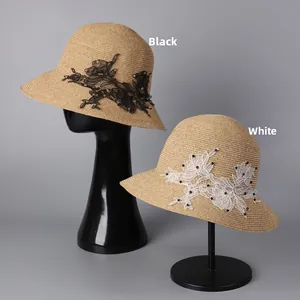 Close-up of woven straw hats featuring delicate lace flower appliques and bead accents