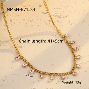Detail of gold necklace featuring teardrop pink crystals and a thick cable chain design