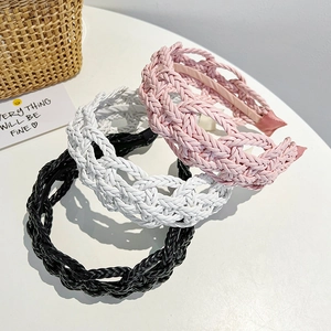 Detailed view of braided leather headbands in pink, white, and black with soft inner lining