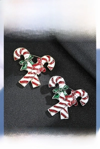 Detailed view of Christmas candy cane brooch with green bow on dark leather background