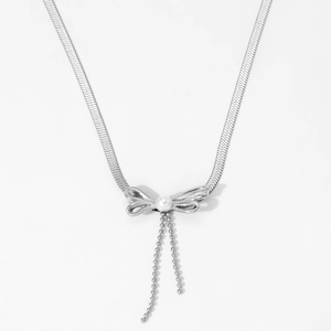 Silver bow necklace set with pearl pendant and snake chain on white background