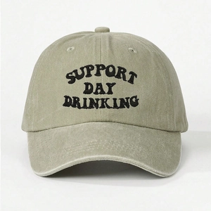 Detailed close-up of embroidered SUPPORT DAY DRINKING text on washed olive cotton cap