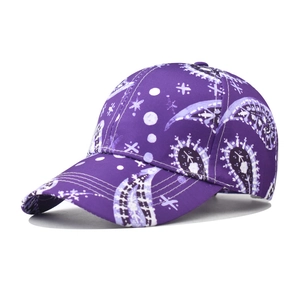 Detail view of purple paisley baseball cap featuring white star patterns and curved brim