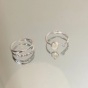 Detail of silver adjustable rings featuring sparkling zircon stones and an oval moonstone