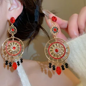Boucles d'oreilles bohèmes dorées avec pierres rouges et perles noires au design ajouré