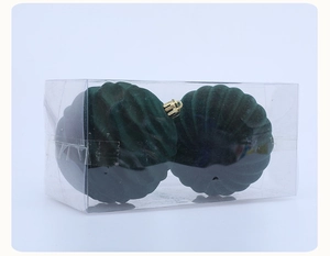 Detail of two dark green flocked Christmas balls with vertical texture in clear gift box
