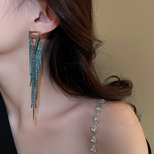 Long geometric tassel earrings with blue-green gradient rhinestones on model