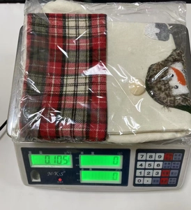 Close-up of a Christmas linen stocking with red plaid pattern and snowman embroidery detail