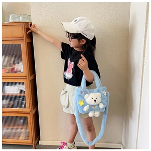 Detail of light blue plush crossbody bag with 3D teddy bear and floral accents