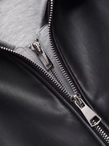 Gros plan sur la veste en simili cuir noir avec double zip et doublure en maille grise