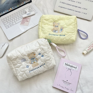Detail of quilted makeup bags with heart patterns and cute cartoon bear embroidery