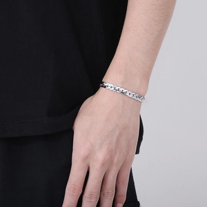 Polished silver stainless steel curb chain bracelet worn on wrist for a minimalist style