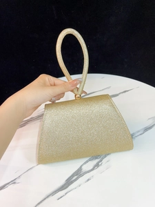 Detailansicht der glitzernden goldenen Pailletten-Clutch mit rundem Griff und Metallverschluss