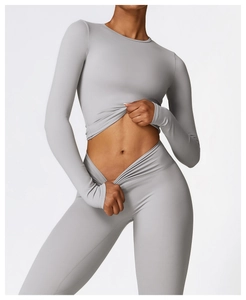 Détail du legging taille haute gris et du haut court à manches longues de yoga