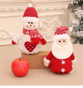 Detail of knitted Santa and snowman figurines beside a red apple in a festive setting