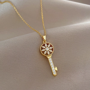 Luxurious gold starburst key necklace with cubic zirconia on a silk background
