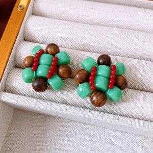 Detailed macro view of colorful beaded earrings with wooden beads and resin accents