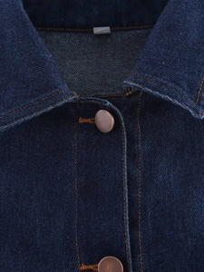 Gros plan du col en denim bleu foncé avec des surpiqûres orange et des boutons en bronze