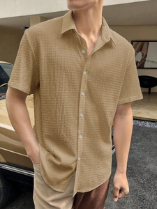 Close-up of khaki seersucker texture on a short-sleeve button-down men's casual shirt