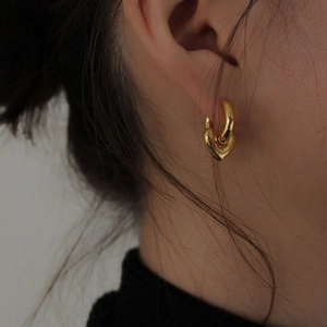 Elegant 925 sterling silver heart hoop earrings in gold finish worn by a model