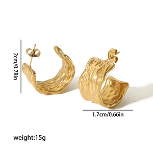 Detailed view of gold C-shaped earrings with irregular hammered texture and dimensions