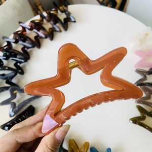 Close-up of caramel pentagram hair claw clip with transparent acrylic and metal spring