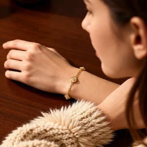 Détail d'un bracelet fleuri plaqué or 18 carats avec zircons porté par un mannequin