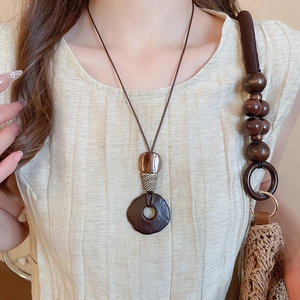 Detail of vintage ethnic resin wood pendant necklace with geometric resin elements