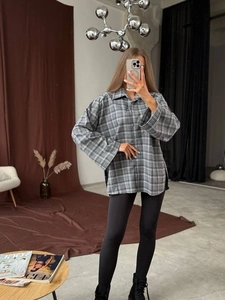 Detail of grey plaid shirt showing side slit and relaxed oversized loose fit cut
