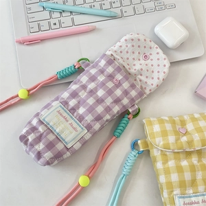 Close-up of quilted cotton camera bags in purple and yellow with colorful neck straps