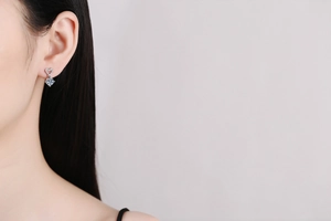 Close-up of s925 sterling silver heart earring with 1ct moissanite on model ear