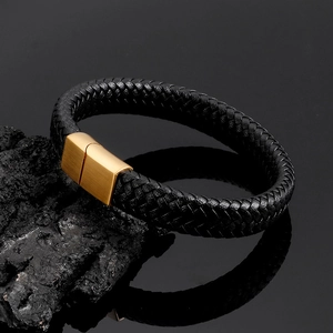 Close-up of braided black leather bracelet with brushed gold stainless steel magnetic clasp