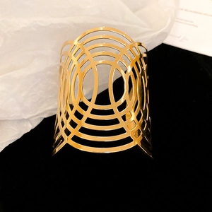 Detalle de brazalete ancho bañado en oro con diseño calado sobre terciopelo negro