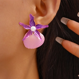 Close-up of beach style starfish and shell earrings with pearls on female model