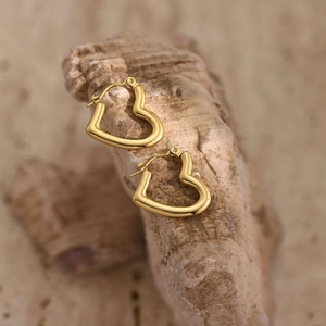 Detail showing the hammered texture of golden heart-shaped stainless steel earrings
