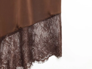 Détail du tissu en satin marron et de la bordure en dentelle sur l'ourlet irrégulier