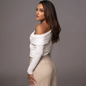 Detail of white off-shoulder ruched bodysuit showing soft fabric texture and pleated design