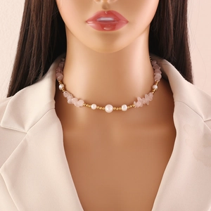 Close-up of handmade necklace with pink natural stones and pearls on a model neck
