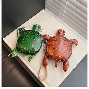 Vue détaillée des porte-monnaie en cuir en forme de tortue avec coque texturée et crochet