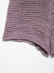 Detailed macro view of mauve purple knit fabric featuring an intricate hollow weave pattern