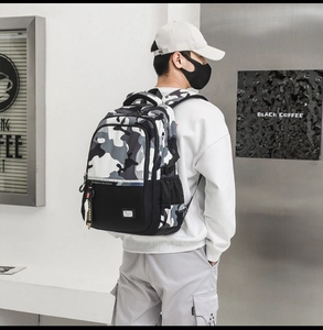 Detailed view of large camouflage backpack with wide padded shoulder straps worn by model