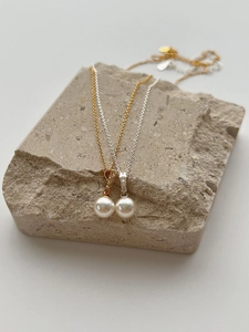 Close-up of S925 silver pearl necklaces with cubic zirconia on natural stone base