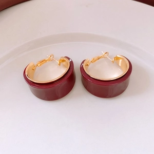 Close-up of deep red resin hoop earrings with 18K gold plated metal inner frame